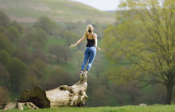 Femme en bonne santé sur un tronc d'arbre